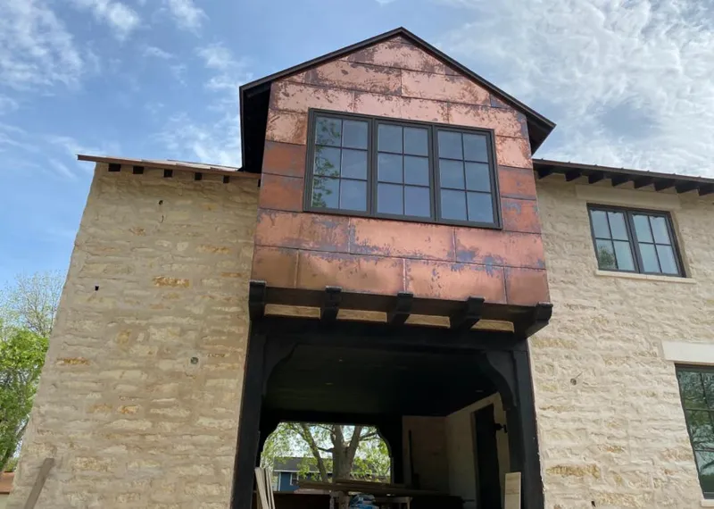 Copper metal panel facade on a stone building for Roof Repair in Cornelia