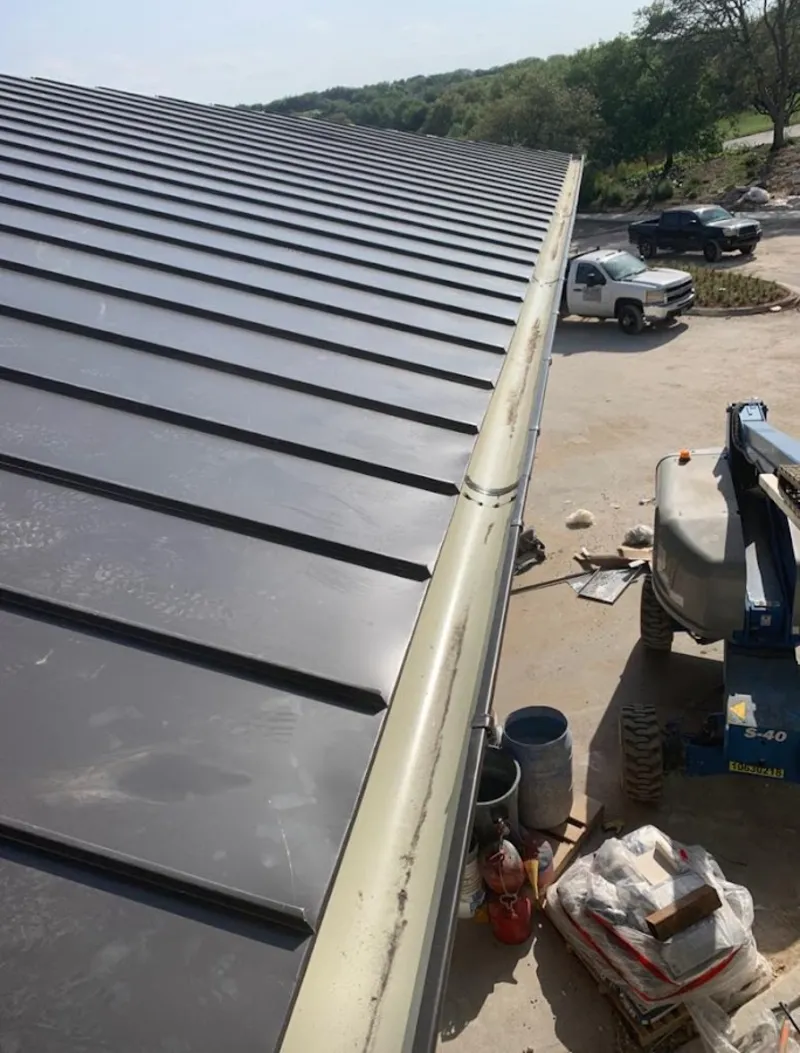 Standing seam panel and gutter detail on a metal roofing jobsite in Cornelia